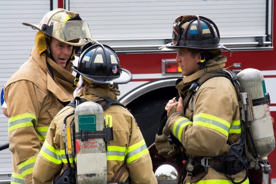 Three fire fighters talking to each other in a small circle