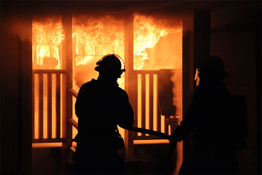 Peer support firefighters putting out a house on fire