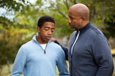 A firefighter out of uniform talking to his son about coronavirus on a walk