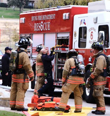 Fire fighters surrounding a fire truck as they remove equipment