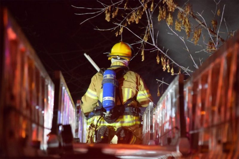 Fire fighter in uniform walking across a bridge at night