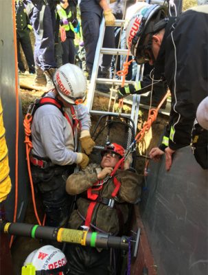 Injured firefighter being pulled out of a hole