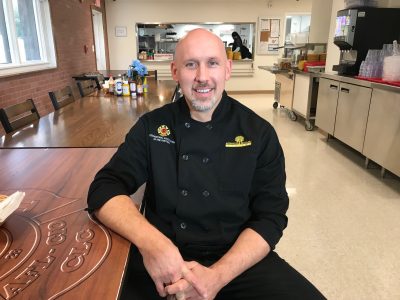 Chef Zachary Pope sitting in the dining hall at COE