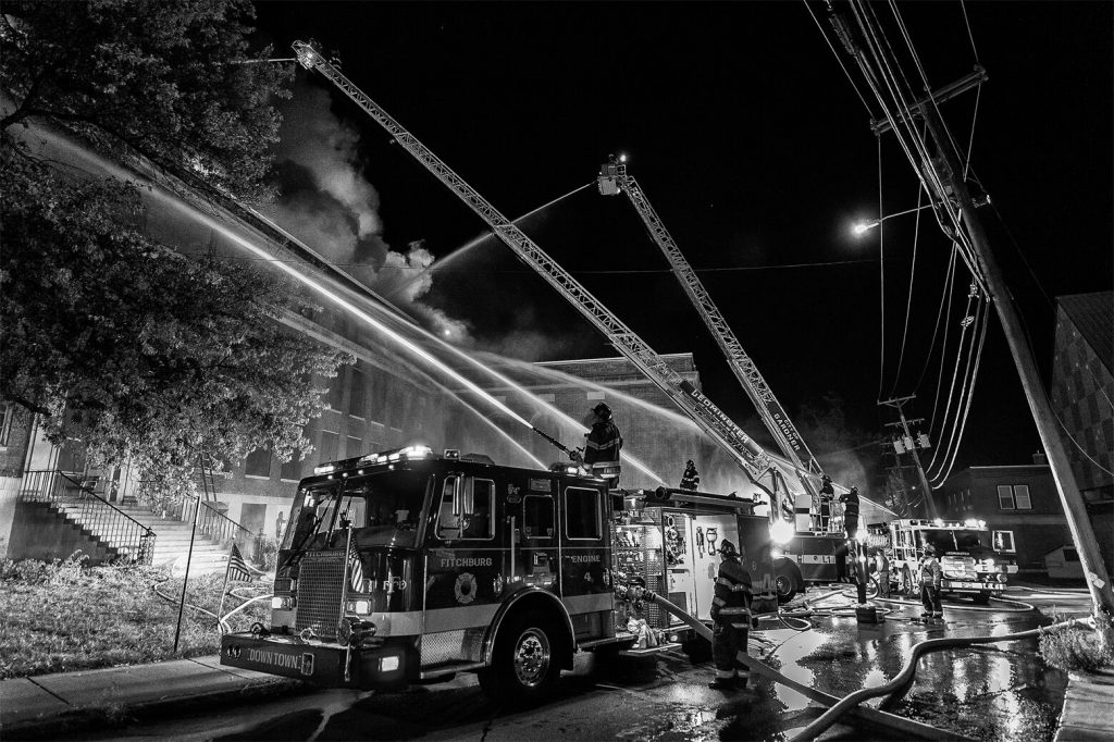 Firefighters using fire trucks to put out a building on fire