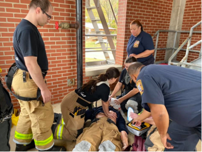 Fire fighters performing medical first aid on an injured fire fighter