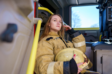 Depressed woman firefighter sitting in a truck looking out of the window
