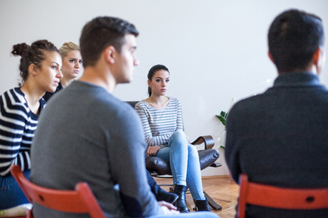 Group of people in recovery sitting in a circle a support group