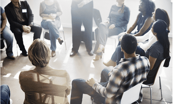 Support group of people in addiction recovery sitting in a circle