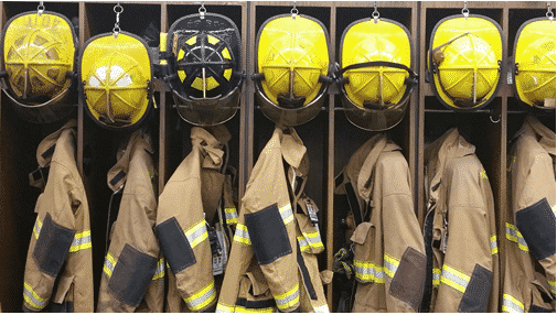 Fire fighter uniforms hanging in cubbys at the station