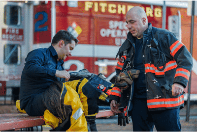 Fire fighters talking in front of a fire truck about recovery