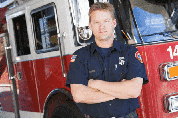 Man standing in front of a fire truck after coming back from rehab