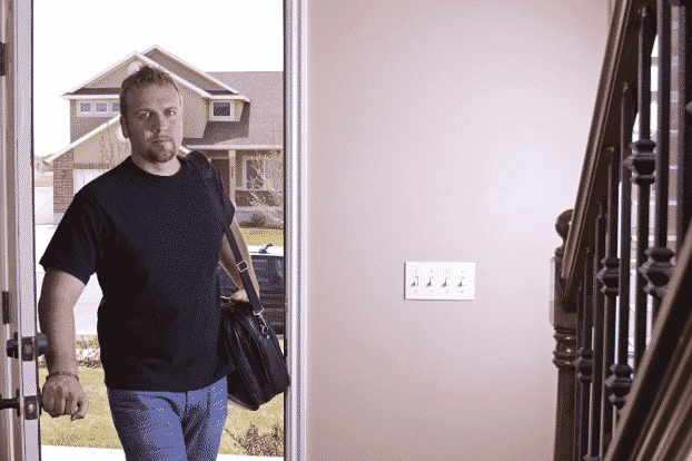 Man walking through the front door of his home after completing rehab