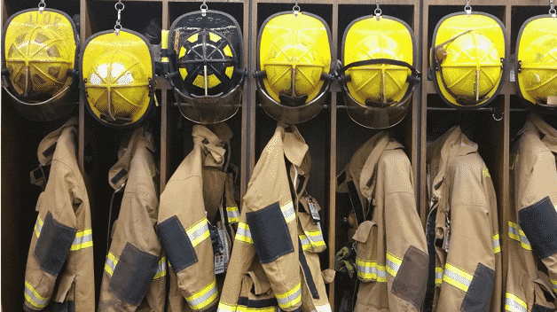 Fire fighter uniforms hanging up in cubbies
