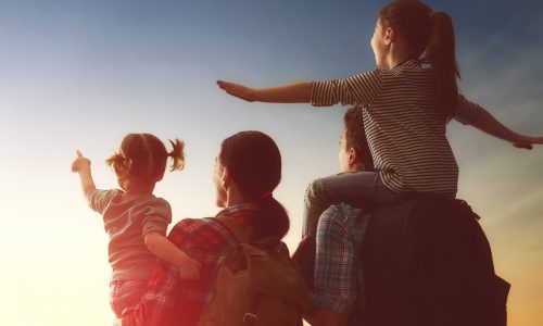 A family looks out at the sunset with hope for a new day.